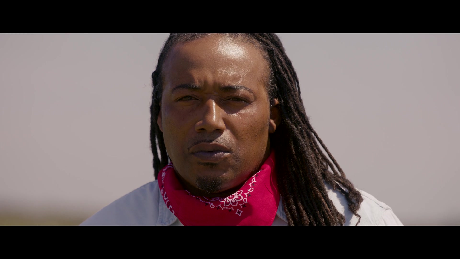 Keith Davis wearing a red bandana in All Cattle, No Hat for Blockchain.com and the Dallas Cowboys